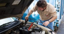 A mechanic doing maintenance on a car battery.